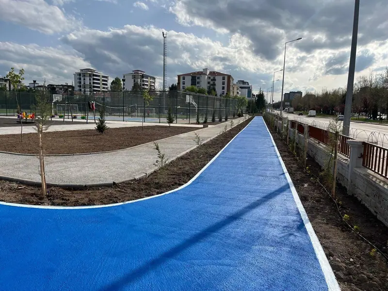 Beyaz kenar çizgili, kıvrımlı mavi bisiklet yolu