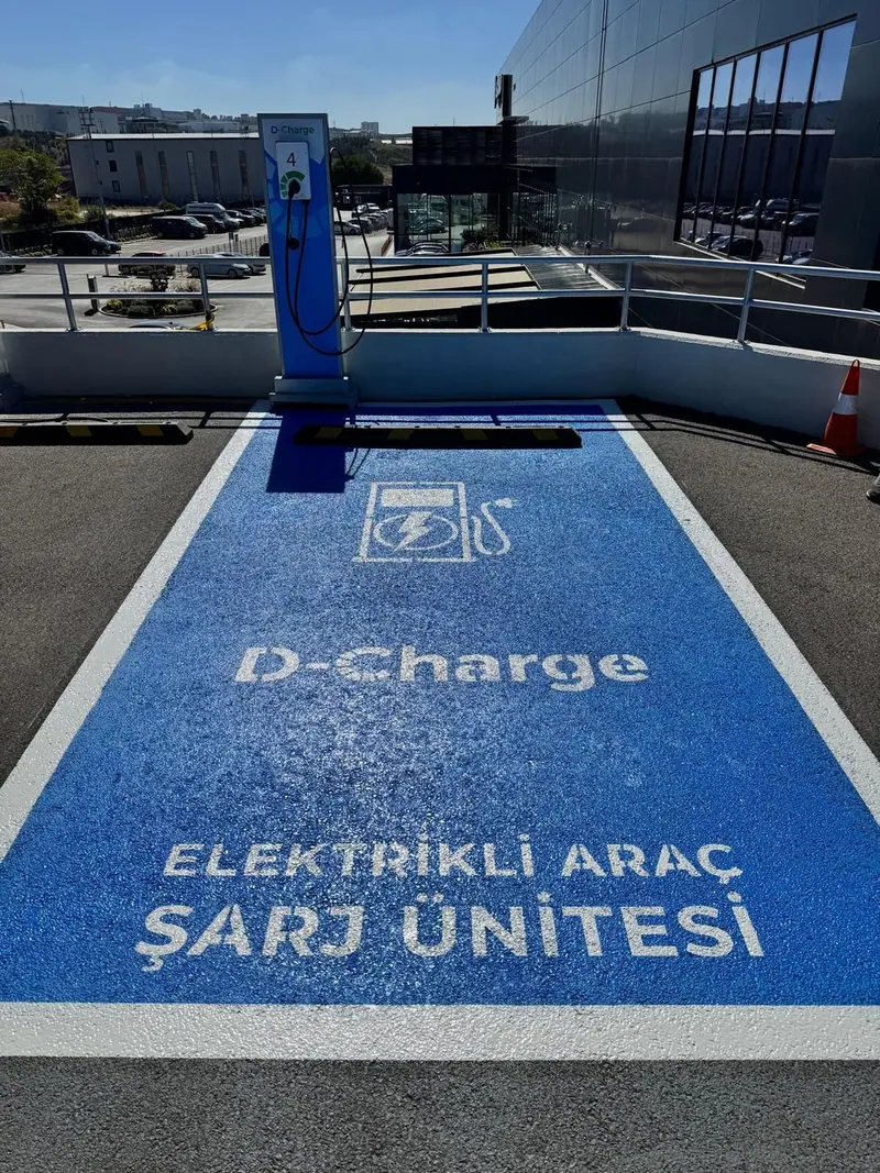 Mavi zemin üzerine beyaz yazılı elektrikli araç şarj ünitesi park alanı