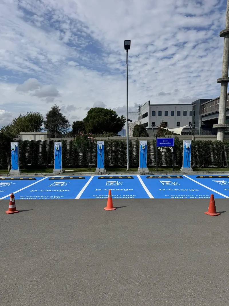 Şarj istasyonları önünde mavi zemin kaplamalı park yerleri