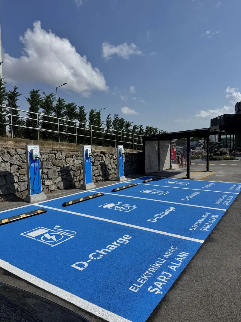 Taş duvar önünde sıralanan mavi elektrikli araç şarj park yerleri