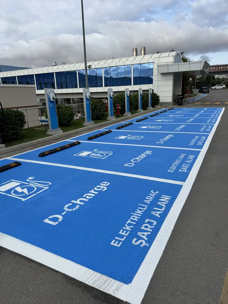 Uzun sıra halinde mavi kaplamalı şarj park alanları