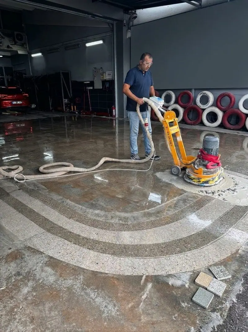 Lastik mağazasında mozaik desenli zeminde silim makinesiyle yüzey hazırlığı