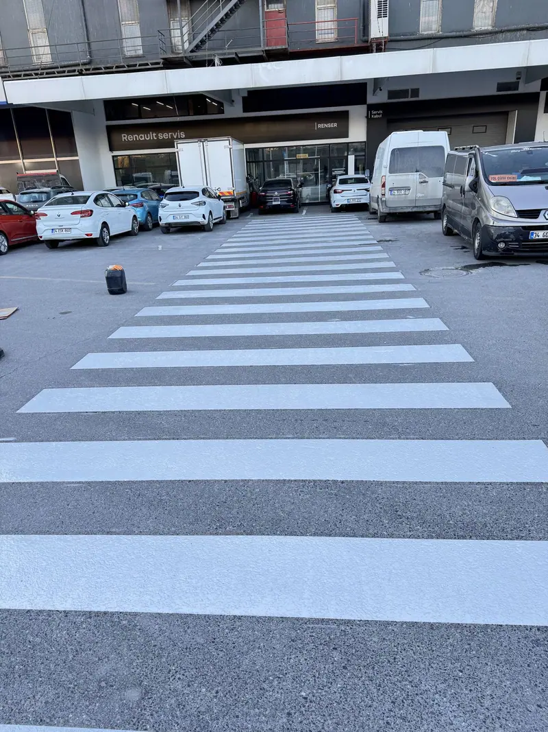 Otopark girişinde beyaz yaya geçidi çizgileri